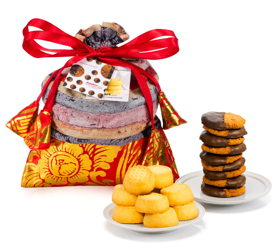 Stacked cookies in a decorative bag with a red ribbon on a white background