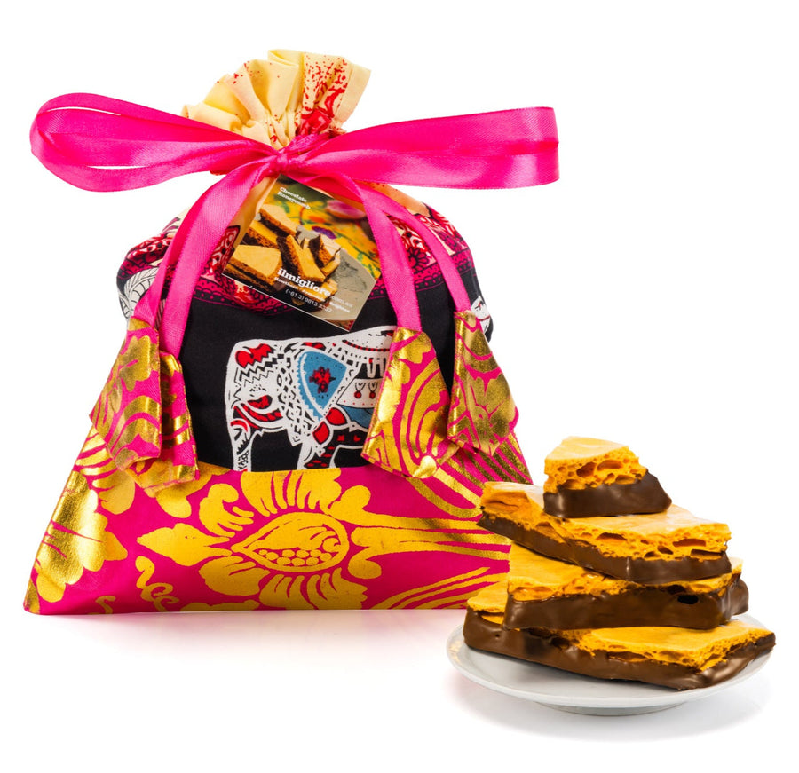 Colorful gift bag with a pink ribbon and cookies on a white background