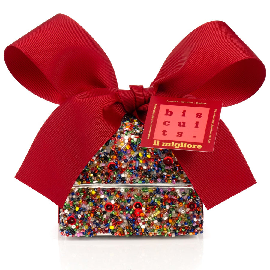 Decorative box with delicious biscuits and a red ribbon on a white background