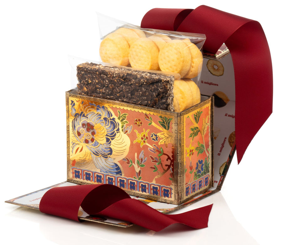 Decorative box with delicious biscuits and a red ribbon on a white background
