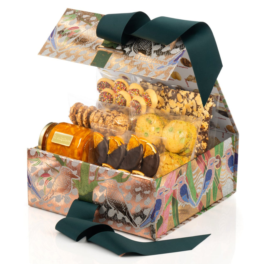 Gift box with decorative packaging containing delicious biscuits on white background