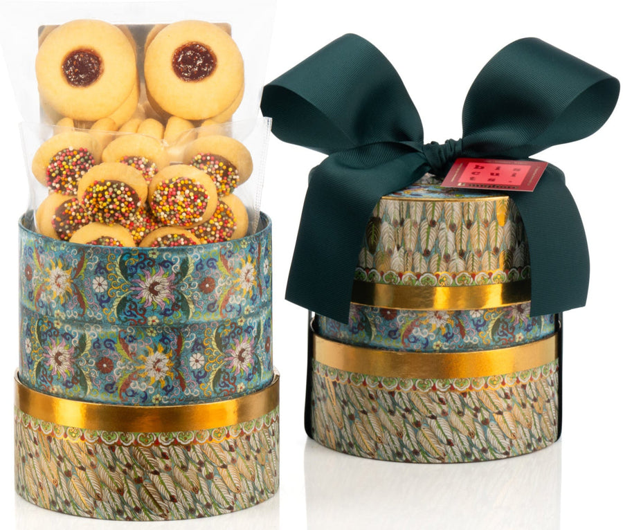 Decorative box with delicious biscuits and a green ribbon on a white background