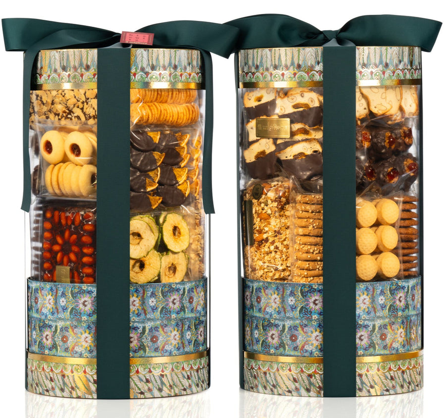 Three cylindrical gift boxes filled with assorted chocolates and biscuits on a white background